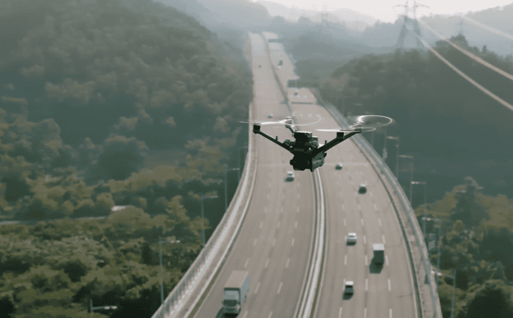Dron industrial en misión de vigilancia autónoma sobre autopista con tráfico, inspección aérea con IA.